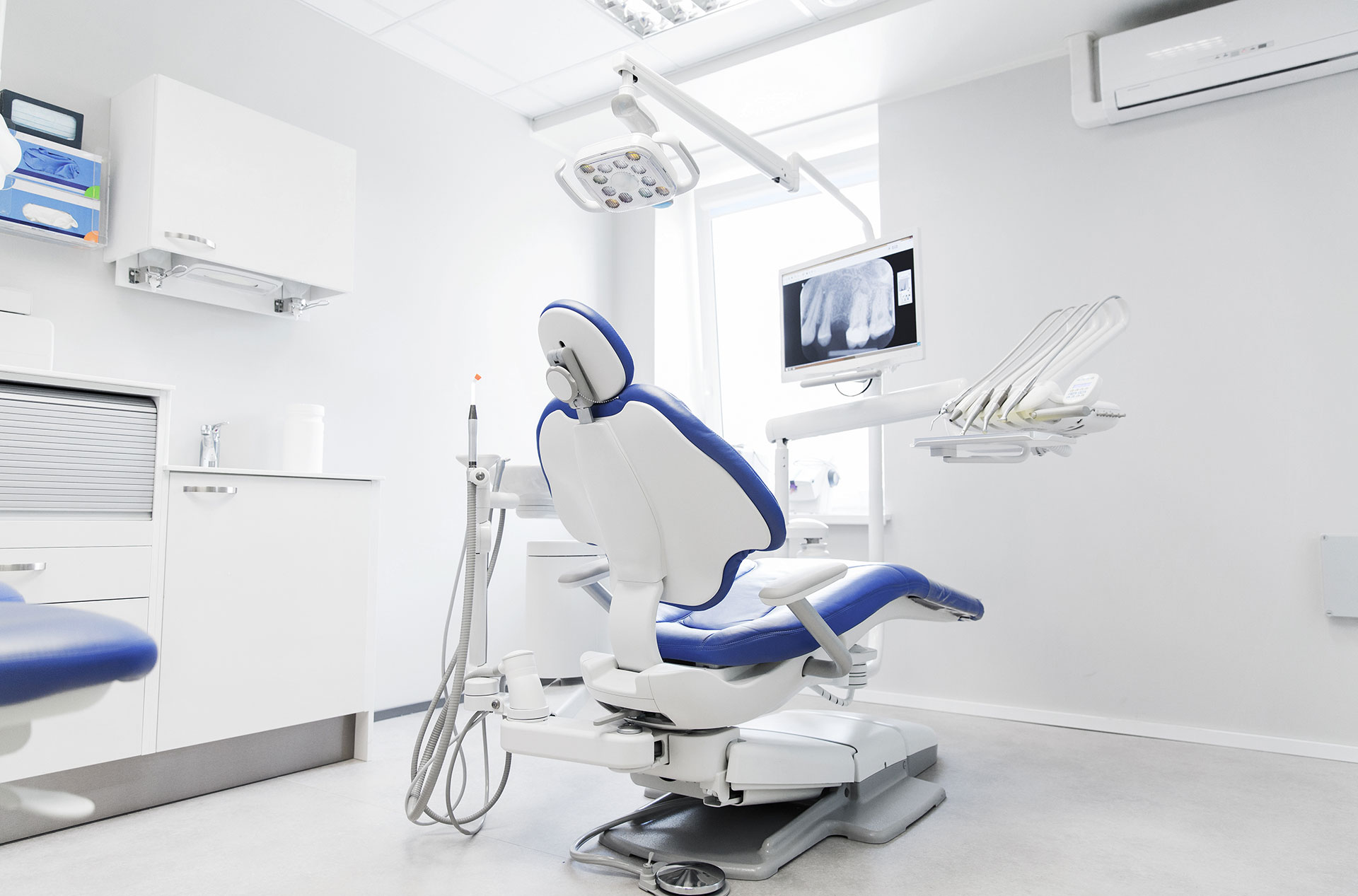 A dental office with a modern chair, equipment, and a clean environment.