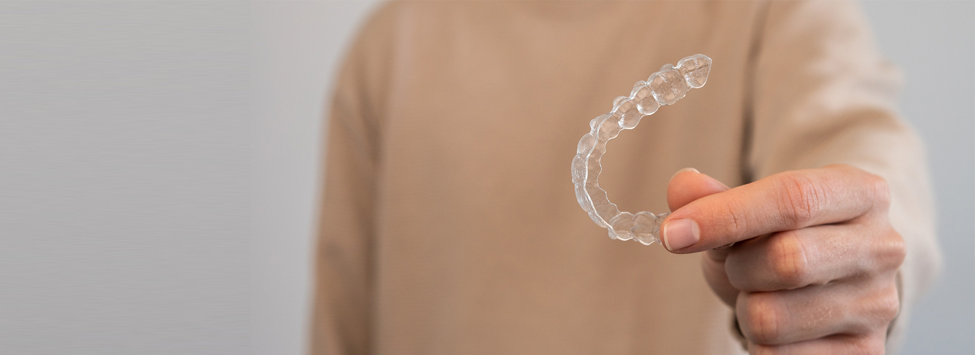 A person s hand holding a soap bubble against a white background.